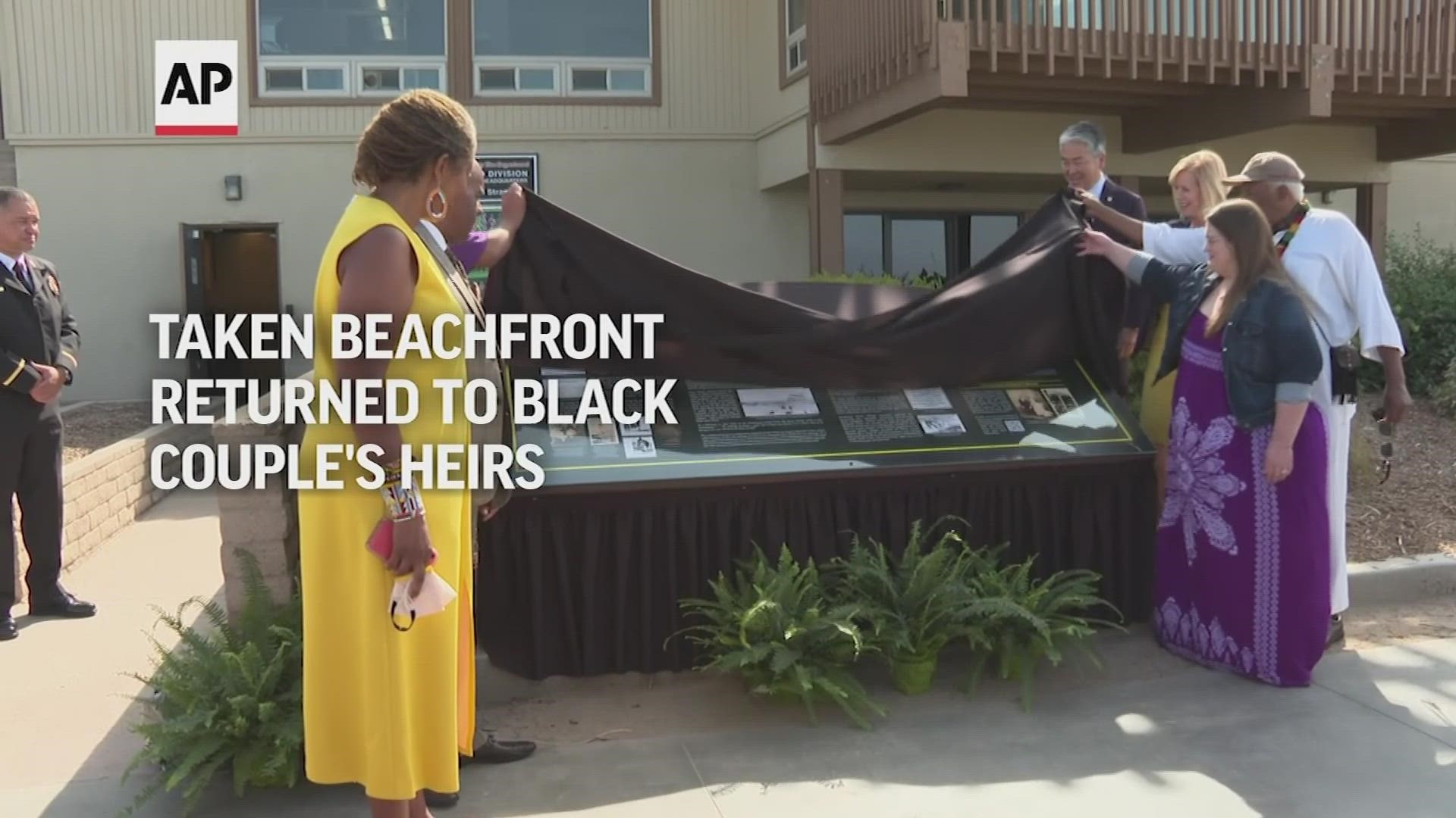 Against the backdrop of waves washing ashore, the county registrar-recorder handed the documents to  the heirs of a Black couple whose property was taken away.