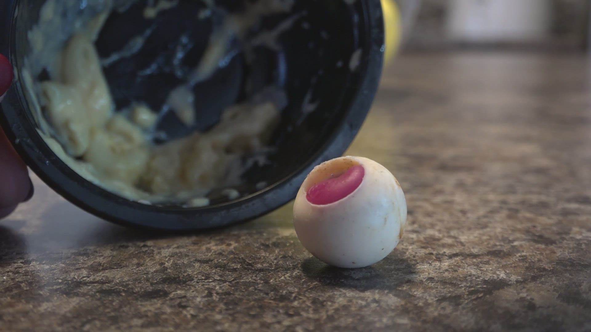 The yellowish orb with brown "veins" and a magenta center is the size of a large gumball. It's squishy and has a chemical smell.