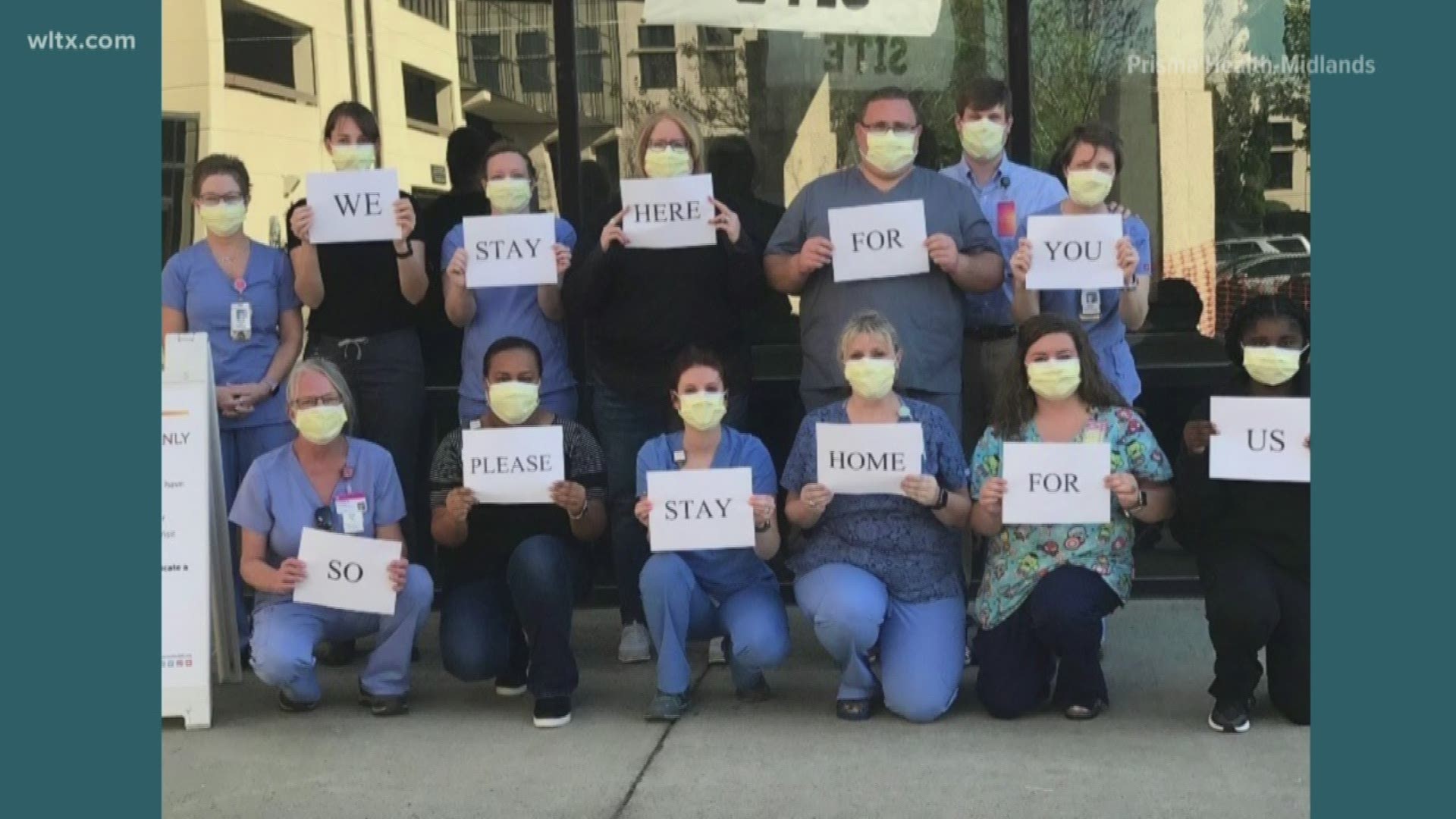 The photo shows health care workers with signs that say 'I came to work so you could stay home'