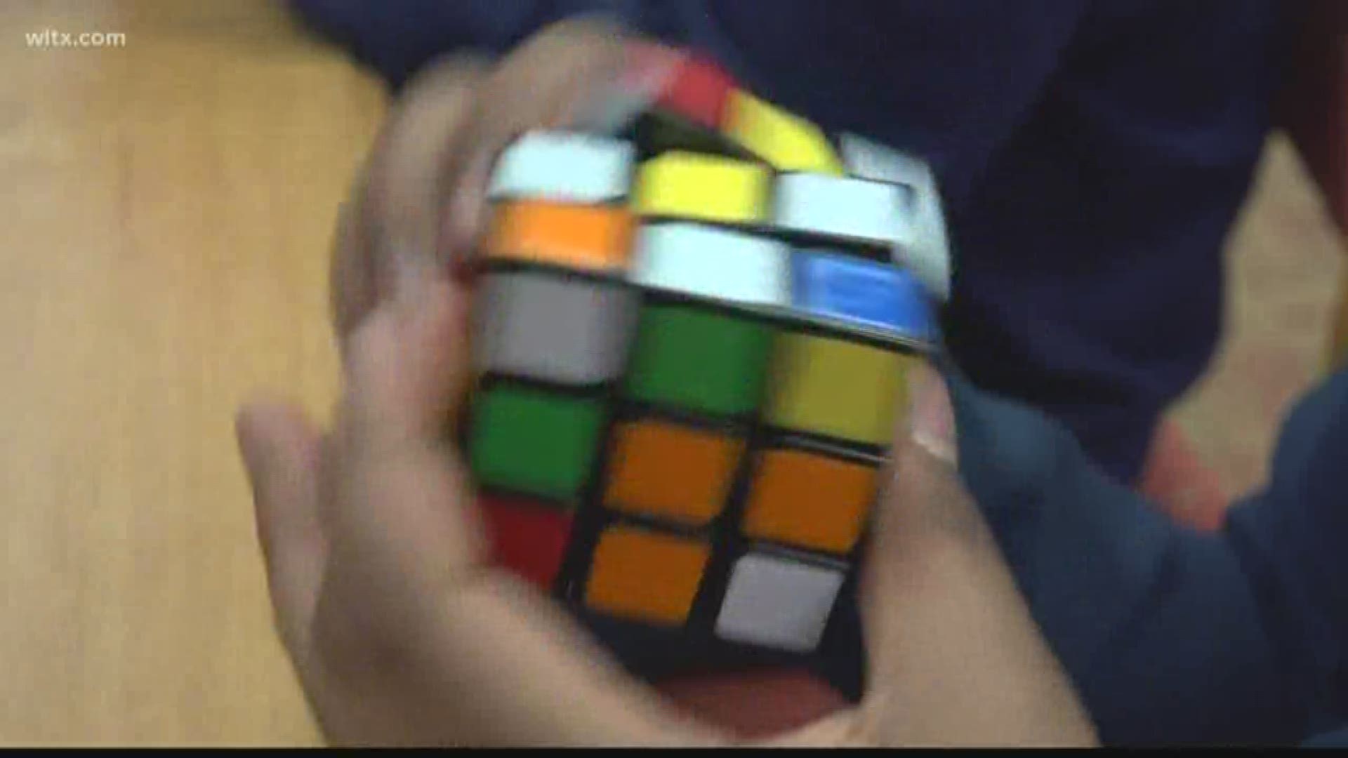 Students at W.G. Sanders Middle School are competing to see who can solve a Rubik's cube the fastest.