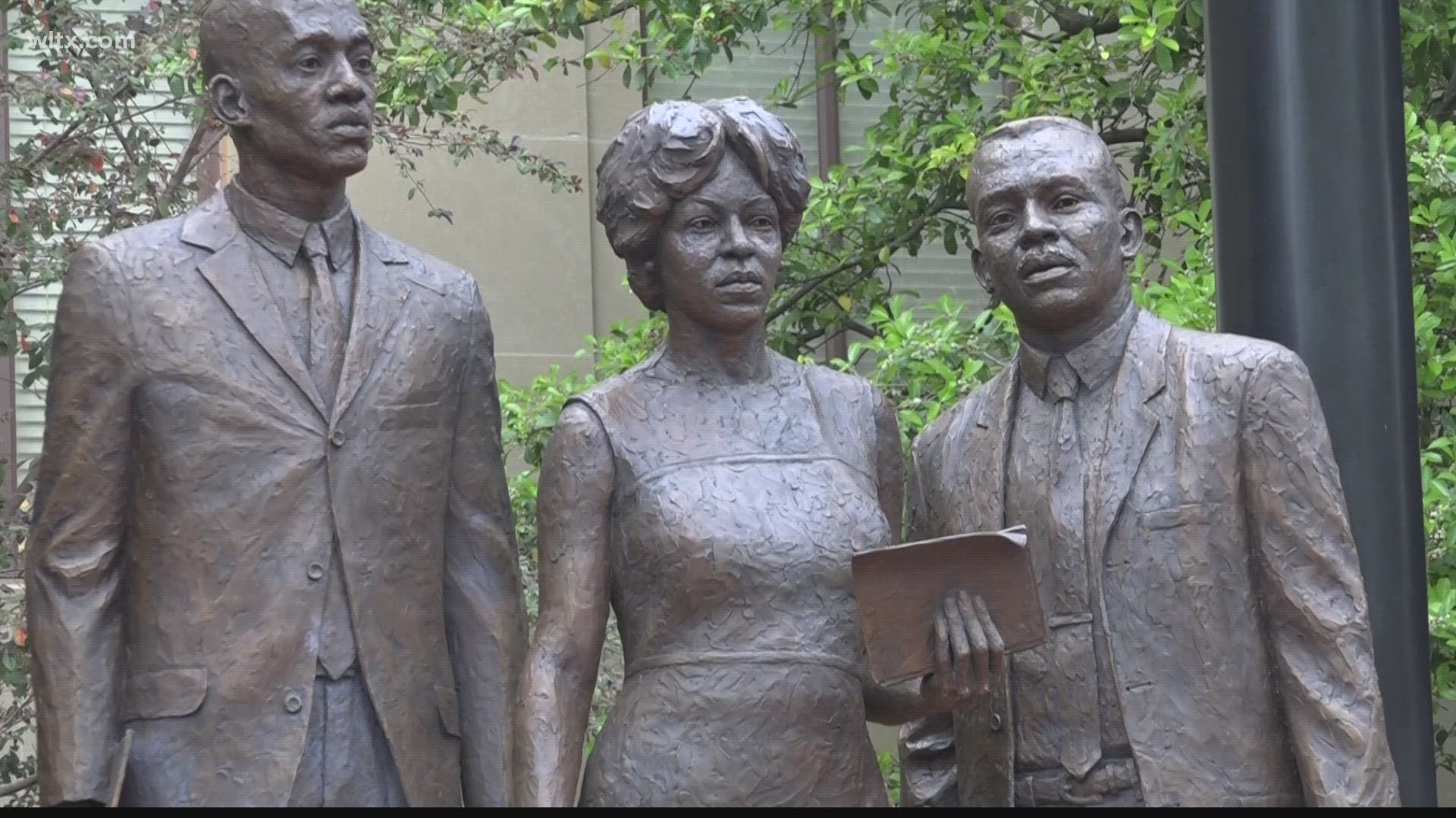 The new 12-foot bronze monument depicts the moment when three Black students desegregated the school in the 1960s.