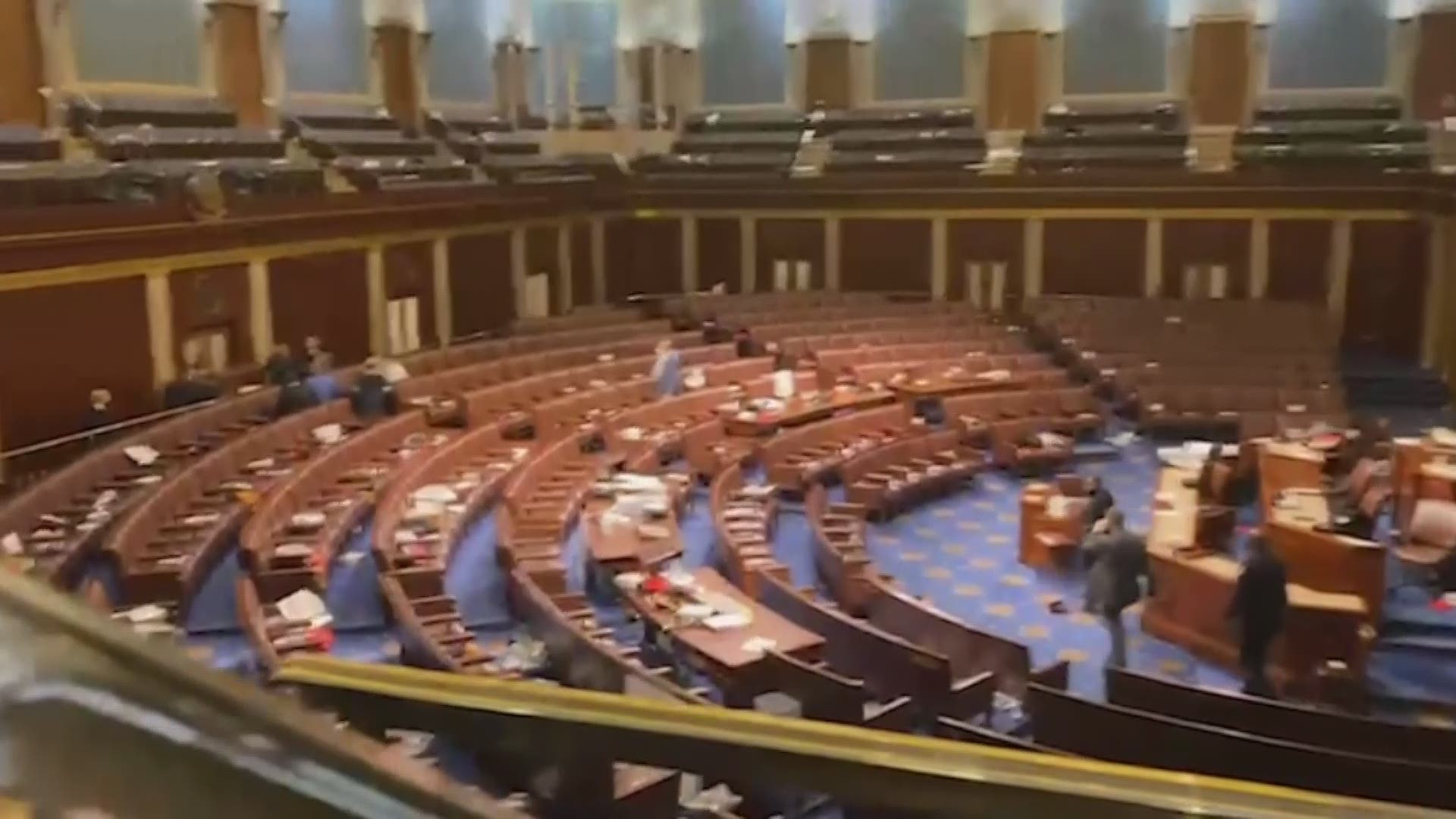 Video from inside the House chamber shows members huddling on the balcony as U.S. Capitol officers stand-off with protesters.