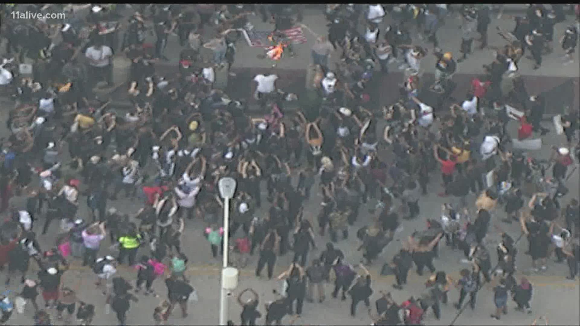 The flag marks the first time in Atlanta's Friday protests that the crowds have burned anything.